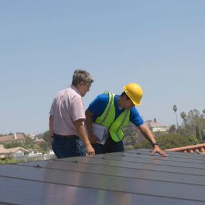 two professionals assessing solar panels